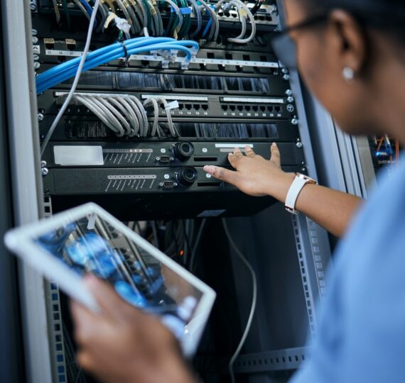 Rearview shot of an unrecognizable female programmer working on a tablet in a server room.